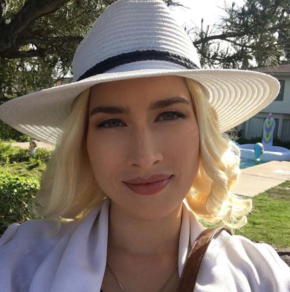 Courtney Anne Mitchell taking a selfie on the outside garden of her house.